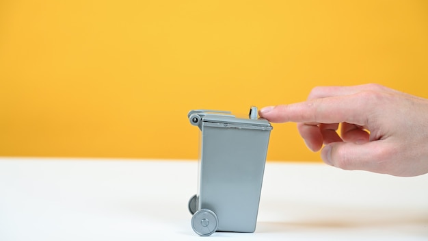 Gray trash can on yellow background.