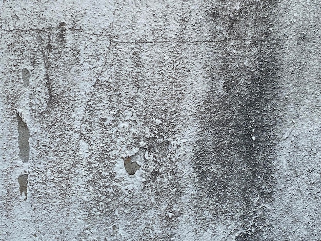 A gray wall with a crack in it.