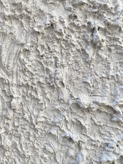 A gray wall with a rough textured surface.