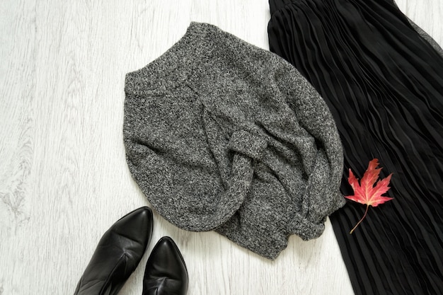 Gray warm sweater, black skirt and boots. Fashionable concept