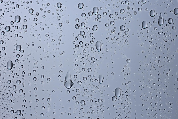 gray wet background / raindrops to overlay on the window, weather, background drops of water rain on the glass transparent