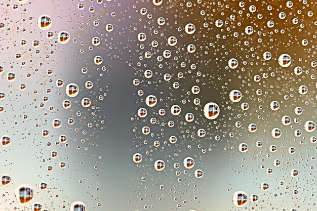 Foto sfondo grigio bagnato / gocce di pioggia da sovrapporre alla finestra, meteo, sfondo gocce d'acqua pioggia sul vetro trasparente