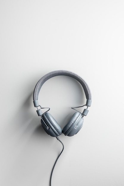 Gray wired stereo headphones on gray background Top view