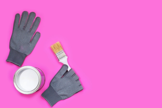 灰色の作業用手袋とブラシ付きの白いペンキ