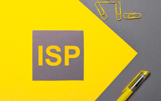 На серо-желтом фоне серая наклейка с желтым текстом ISP Internet Service Provider, желтые скрепки и желтая ручка.