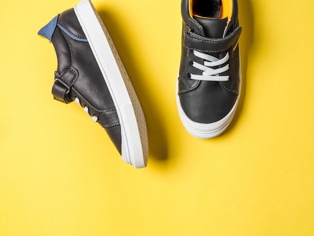 Gray and yellow sneakers on yellow background