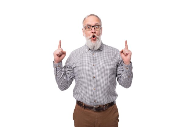 Foto un uomo maturo dai capelli grigi con barba e baffi in pantaloni e camicia è emotivamente infastidito