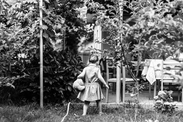 Photo grayscale back view of a child playing in the garden
