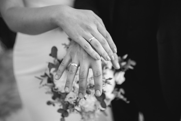 Grayscale newlyweds demonstrating the wedding rings