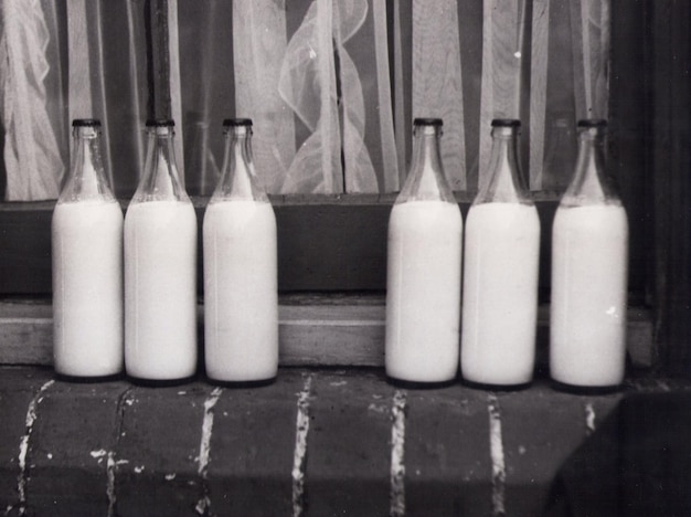 Grayscale Photo Of Bottles In Groups with Milk Photo