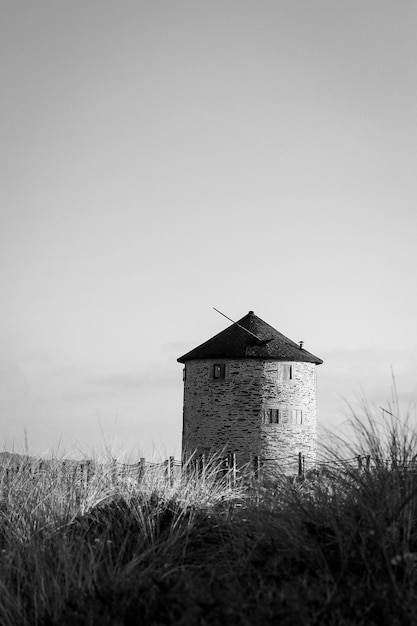 Снимок в оттенках серого старой традиционной ветряной мельницы в Апулии, Португалия