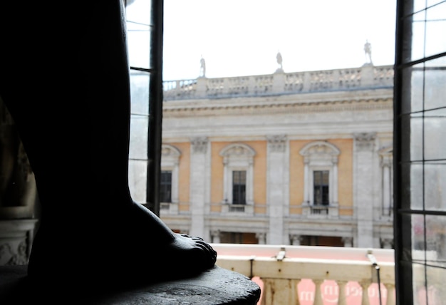 ローマのカピトリーノ美術館の大きな中央ホール 窓からはカンピドリオが見渡せます 巨大なバサナイト像は赤ちゃんヘラクレスを描いています ローマ イタリアの部屋の真ん中にあります