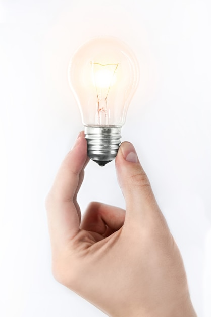 great idea concept the man's hand holding a glowing light bulb on a white background