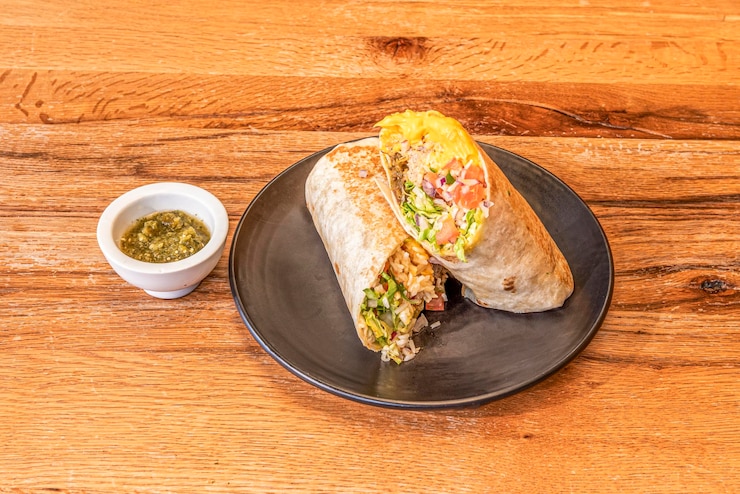 Photo great mexican burrito filled with carnitas with rice and pico de gallo chili sauce and grilled wheat tortilla