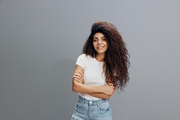 Great offer happy overjoyed pretty latin female with afro
folded arms crossing hand smiling at camera laughing stay isolated
over gray background copy space free place fashion banner