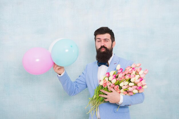 Great pleasure. love date with flowers. happy birthday. spring
bouquet. 8 of march. womens day. formal mature businessman bearded
man in bow tie with tulip flowers. bride groom at wedding
party.