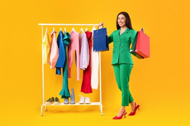 Great sales excited shopaholic lady holding colorful shopping bags happy about new clothes standing