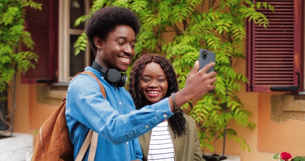 Great selfie waist up portrait view of the multiracial couple in love making selfie at the smartphon...