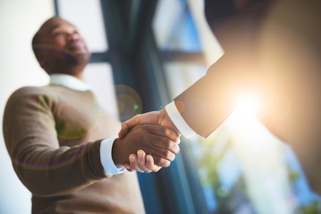 Great things can only be achieved together Closeup shot of two businessmen shaking hands in an office