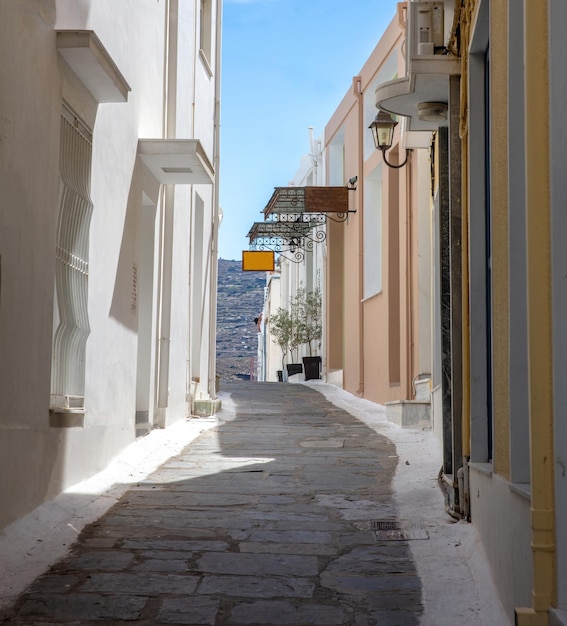 Greece Cyclades Andros island Chora Empty alley traditional wall blue sky background Vertical