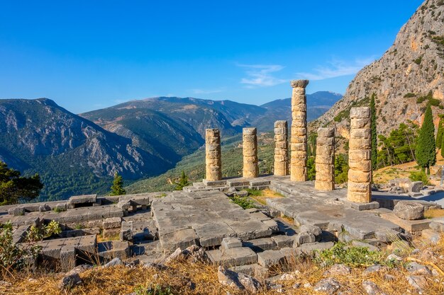 ギリシャ。デルファイ。日当たりの良い山々と青い空を背景にした古代遺跡