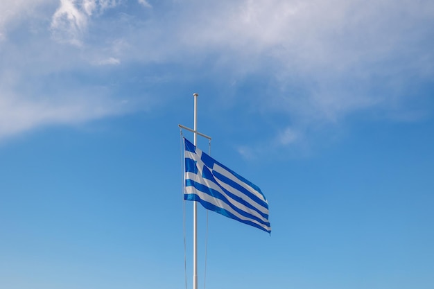 Greece flag is flying in air on blue sky background Banner place for text