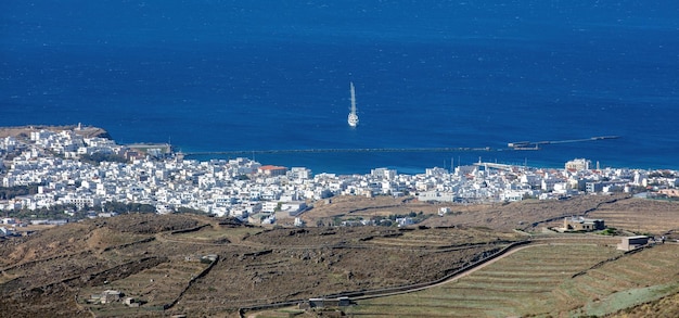 Greece Tinos island Cyclades Aerial drone panoramic view of Hora white building port blue sea