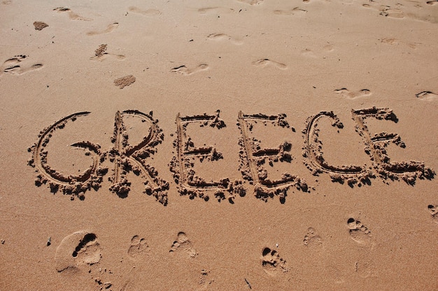 Foto la grecia scritta nella sabbia sulla spiaggia