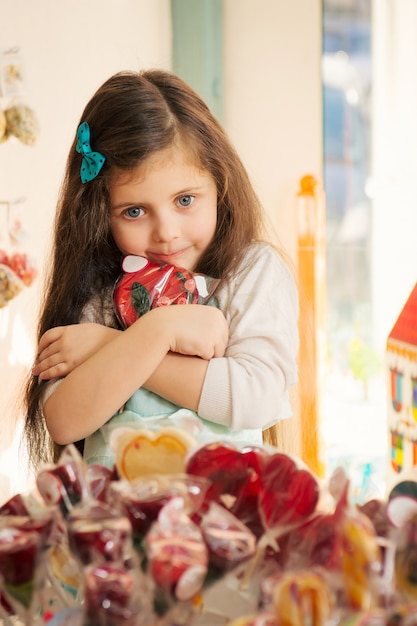 Avidità bambina con lecca-lecca nel negozio di caramelle