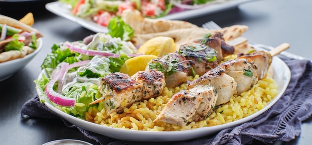 Piatto di souvlaki di pollo greco con pane pita, insalata e riso