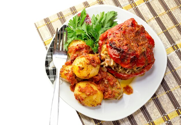 Greek cuisine Fresh cooked sweet pepper with sauce stuffed with rice vegetables and potatoes on a plate closeup