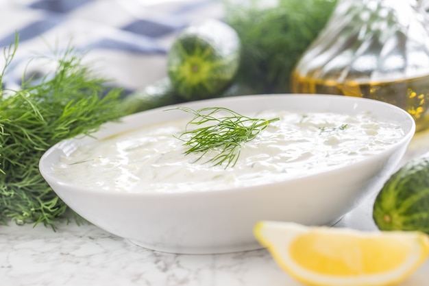 Greek dip or dressing tzatziki prepared with cucumber sour cream yogurt olive oil and fresh dill