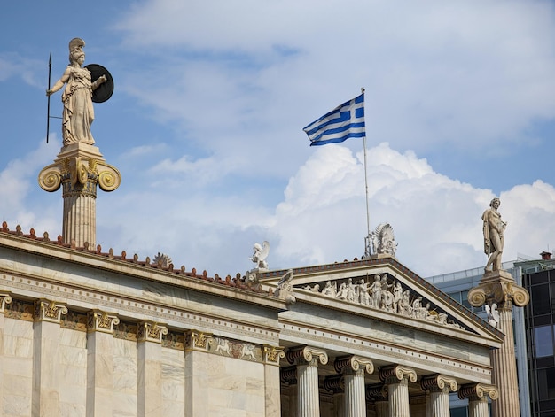 A greek flag flies on top of a building.