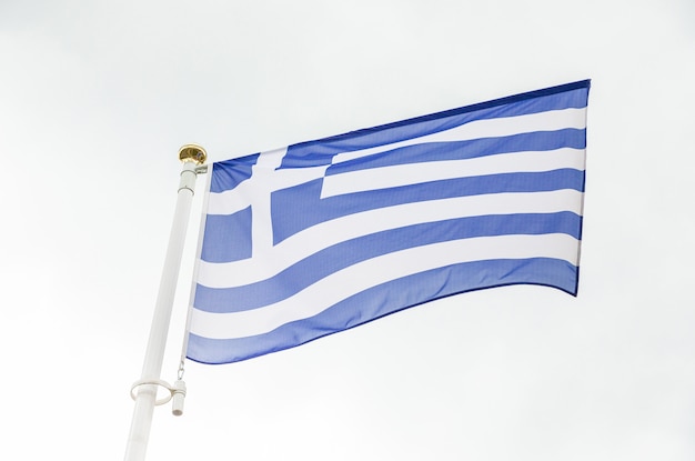 Greek flag waving in the wind against sky