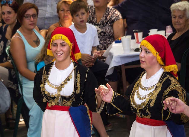 ギリシャの祭りで伝統的なギリシャ舞踊を踊る民族衣装を着たギリシャの女の子