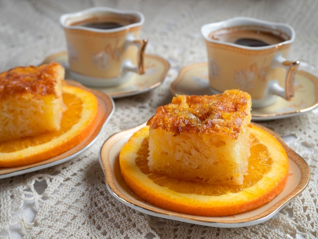 Greek orange pie with orange slices and coffee on a handmade knitted tablecloth in Greece