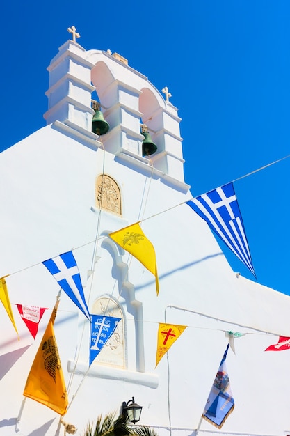 Greek othodox church drcorated by flags in celebration of religious holiday, Mykonos island, Greece