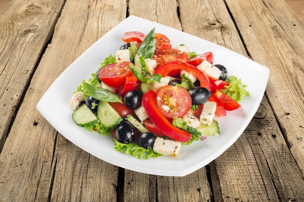 Греческий салат - сыр фета, оливки и овощи, изолированные на белом фоне