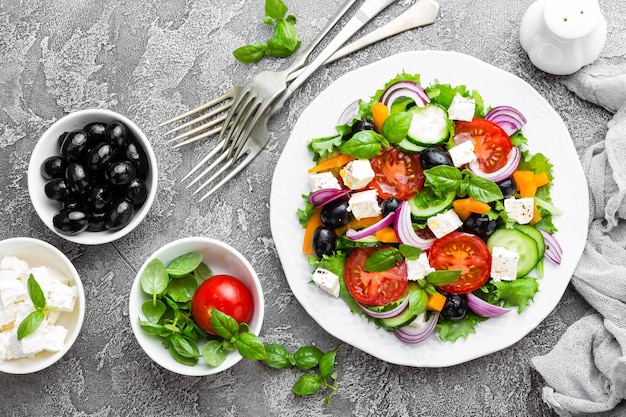 Greek salad Fresh vegetable salad with tomato onion cucumbers pepper olives lettuce and feta cheese Greek salad on plate