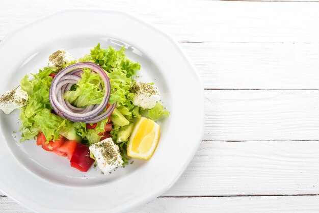 Greek Salad from Fresh Vegetables On a wooden background Top view Copy space