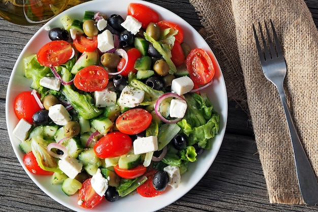 Greek salad of raw vegetables seasoned with olive oil salt and oregano