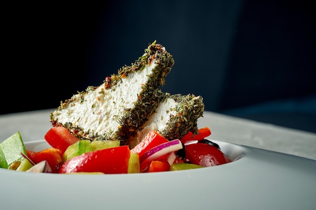 Greek salad with feta cheese and vegetables in a white plate