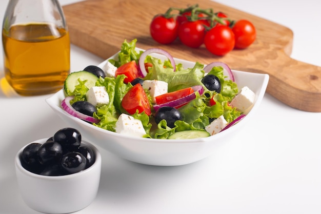 Греческий салат со свежими помидорами, огурцами, оливками, сыром фета и красным луком. Здоровое и диетическое питание