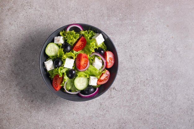 Insalata greca con pomodori freschi, cetrioli, olive, formaggio feta e cipolla rossa