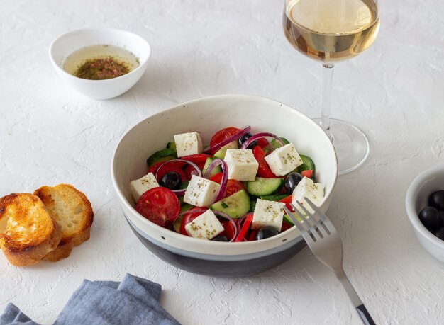 Greek salad with tomatoes, cucumbers, cheese, onions, peppers and olives