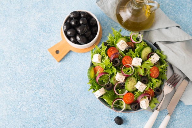 Greek salad with tomatoes, cucumbers, olives and feta cheese in a plate on a concrete background, typical Greek cuisine, copy space