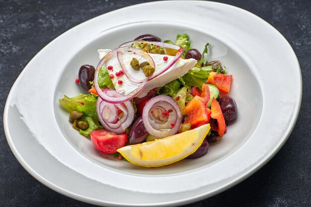 暗い背景に野菜とチーズのギリシャ風サラダ