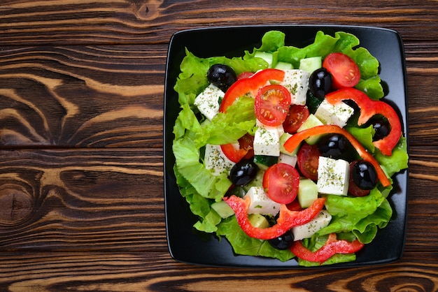 Greek salad on a wooden background