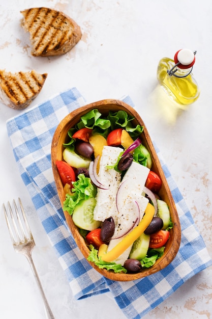 Greek salad in wooden plate