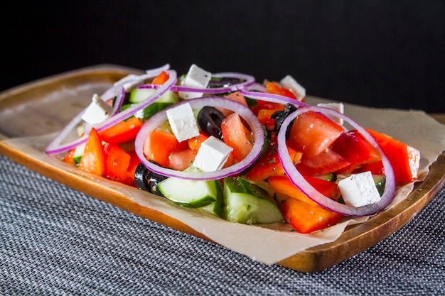 Insalata greca in un piatto di legno